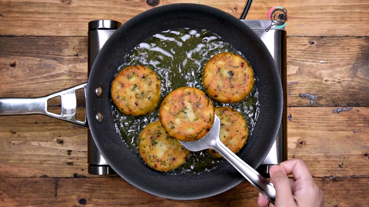 Golden fried crisp aloo tikki in pan, ready to serve.