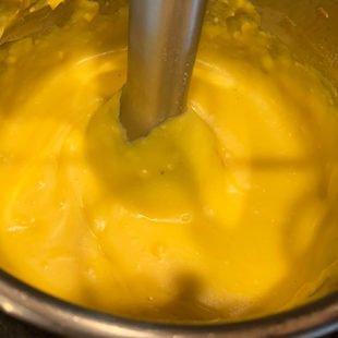 an immersion blender blending the dal