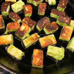 paneer pieces being pan fried on a skillet