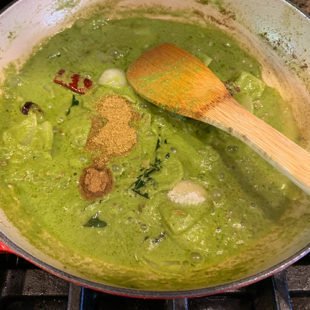 spices added to a green color curry