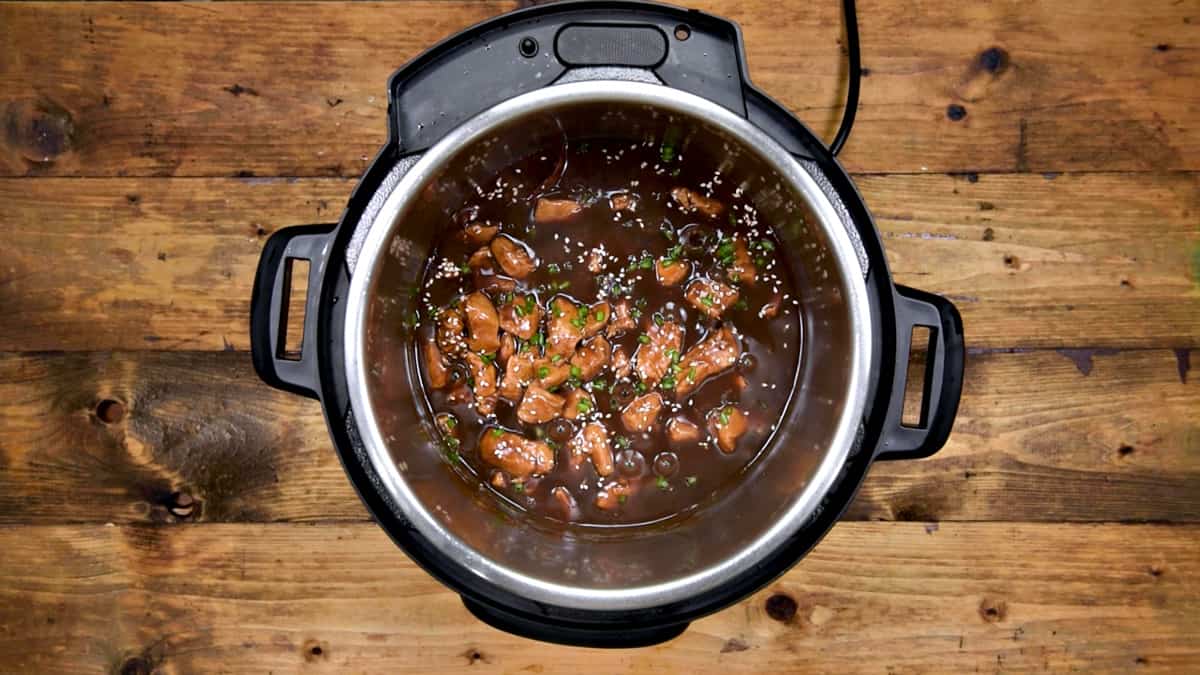 Instant Pot General Tso's chicken garnished with sesame seeds and green onions, it's ready to serve.