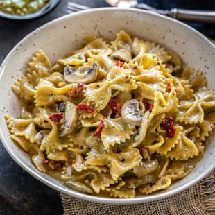 bowl of bow-tie pasta with mushrooms and sun-dried tomatoes